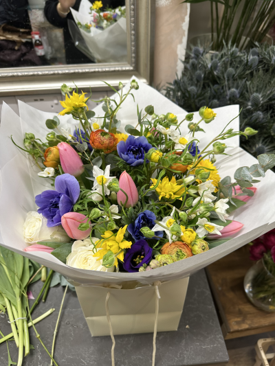 SL-01 - Spring selection please allow a day notice to be the best match or we can select the best match on the day available picture shows standard size with pink tulips yellow butterfly ranunculus white roses orange ranunculus and white narcissus purple lisianthus