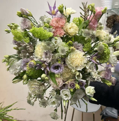 fresh day - very light and fresh spring colours purple clementis green viburnum  cream carnations light liac lisianthus and white lisianthus astrantia ,if need the same like the picture please allow one working day .picture show a medium size